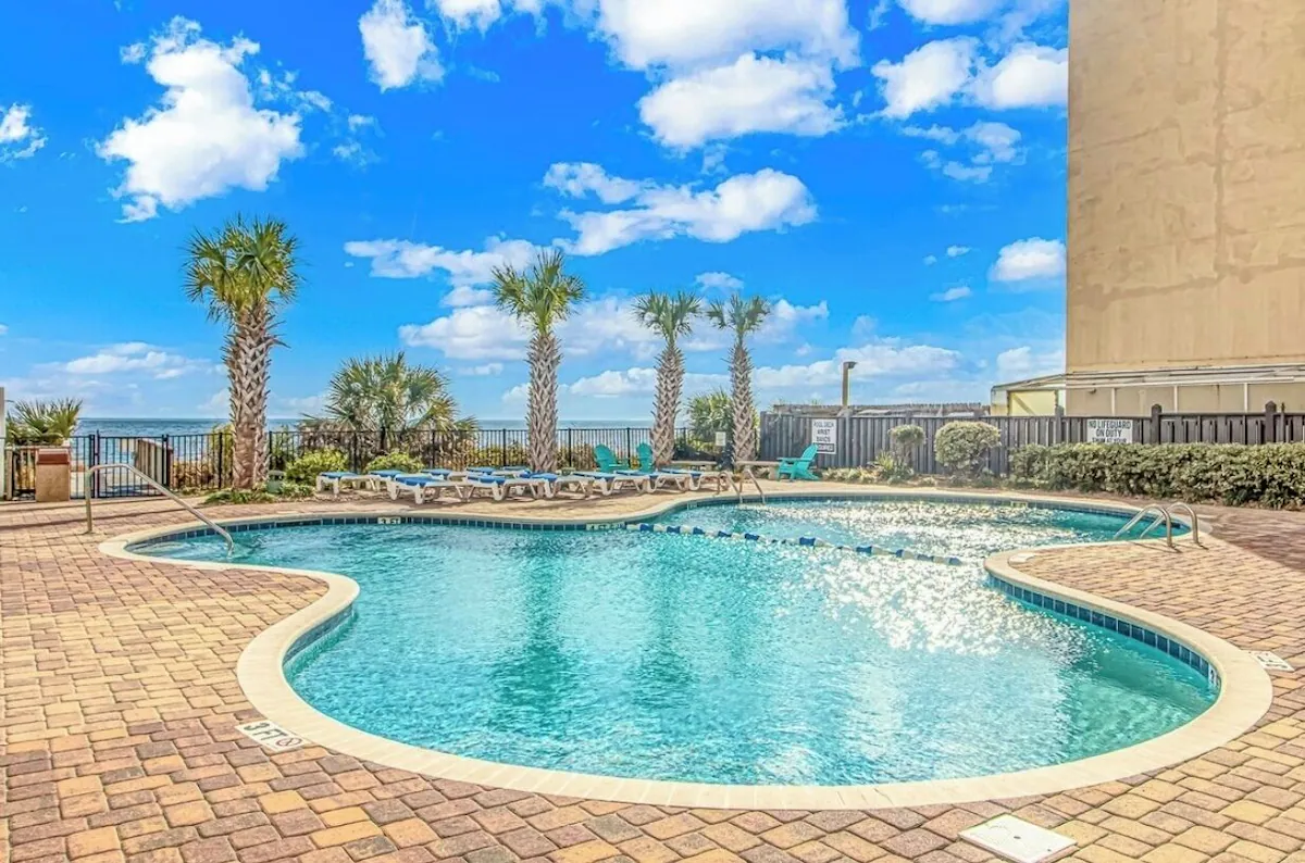 Oceanfront resort pool with palm trees and lounge chairs in Myrtle Beach
