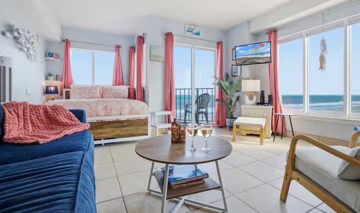 Living area with sleeper sofa and ocean-facing windows in the beachfront studio