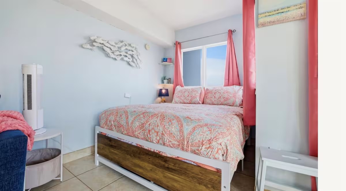 Queen bed with soft coastal linens in the Myrtle Beach oceanfront studio