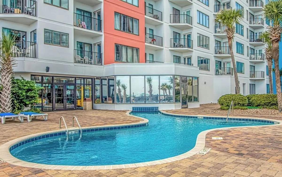 Outdoor pool and deck beside the oceanfront resort building in Myrtle Beach